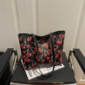 Fashionable black tote bag featuring vibrant red cherry prints and long shoulder straps - Black