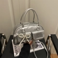Metallic silver crossbody bag with mirror finish, double pockets and pearl bow charm - Silver