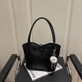 Minimalist black faux leather tote bag with a white cartoon plush ball charm on a chair - With Monster Pendant / Black