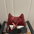 Dark red patent leather underarm bag with silver rivets and vintage buckle detail - Red