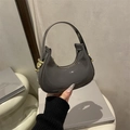 Chic dark grey patent leather dumpling bag with glossy finish and gold metal accents - Gray