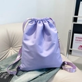 Mochila minimalista de nailon lavanda con cordón ajustable en un sofá suave - Morado