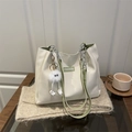 Minimalist beige tote bag with green straps and fashion label in a lifestyle setting - With Pendant / Green