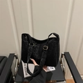 Chic black leopard pattern shoulder bag with gold hardware on a modern chair - Black