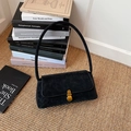 Vintage black underarm bag with pleated texture and bronze metal clasp on a woven mat - Black