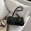 Minimalist black PU leather baguette bag with gold buckles on a white sofa scene - Black