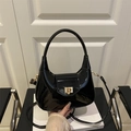 Minimalist black patent leather crescent shoulder bag with golden lock and strap - Black