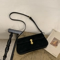 Detalle del bolso de hombro en ante negro mate con un cierre cilíndrico de metal dorado - Negro