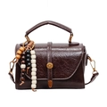 Brown vintage faux leather handbag with glossy texture and bohemian beaded charm - Brown
