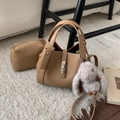 Detail of light brown lychee grain handbag with plush rabbit charm on a cozy rug - With Charm / Khaki