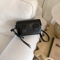 Detail of black glossy leather crossbody bag with silver heart pendant on white fabric - No Pendant / Black