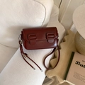 Close-up of deep red rectangle shoulder bag with heart charm on a white fabric sofa - No Pendant / Burgundy