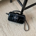 Close-up of black crossbody bag with silver buckle on cozy beige faux fur rug - Black without Pendant