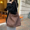 Large dark brown suede tote bag with wide shoulder strap shown on a model - Coffee