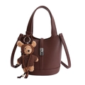 Bolso cubo de cuero marrón oscuro con grabado de lichi, cierre y colgante de oso - Café Con Colgante