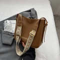 Brown leather tote bag with ethnic pattern wide strap on a grey blazer suit - Brown