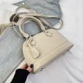 Detailweergave van de beige handtas met metalen noppen en zilverkleurige hardware - Groot / Broken Wit