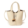 Minimalist cream textured leather bucket bag with top handle and woven tassel detail - With Charm / Off White