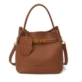 Brown lychee leather bucket bag with white stitching and bear charm on white background - Brown