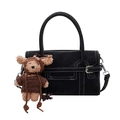 Black leather handbag with white stitching and a cute bear plush charm accessory - Black