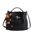 Elegant black lychee leather bucket bag with top handle and cute bear charm accessory - Black