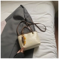 Elegante bolso bandolera beige con borde marrón y colgante étnico de cuentas de madera - Blanco