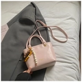 Pink bucket bag with top handle and adjustable strap featuring beaded charm detail - Pink
