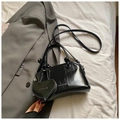 Dettaglio della borsa nera lucida con ciondolo a cuore e logo del marchio in rilievo - Stile con Ciondolo a Cuore / Nero