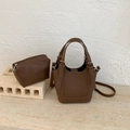 Gros plan d'un ensemble de sacs seau marron avec détails argentés et texture cuir - Avec Pendentif / Marron