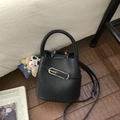 Détail du sac seau en cuir grainé noir avec boucle argentée et bandoulière réglable - Avec Pendentif / Noir