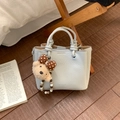 Détail du sac à main gris clair en cuir avec texture et charmant ours en peluche - Avec Pendentif / Blanc Cassé