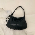 Detail of minimalist black soft leather tote bag with stylish knot strap and logo tag - Black