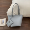 Detail of light blue lychee pattern tote bag with matching coin purse on wooden floor - Blue