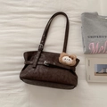 Close-up of retro brown leather tote bag with decorative plush bear charm and strap detail - Brown