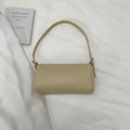 Close-up of pebble leather texture and silver buckle on chic cream pillow bag - Khaki