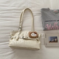 Detail of a creamy off-white tote bag with thin straps and a cute brown plush charm - Off-white