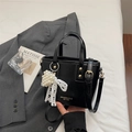 Glänzende schwarze Beuteltasche mit Perlenherz-Anhänger und weißer Spitzenschleife - Schwarz