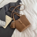 Chic brown ruched bucket bag with decorative buckle, fringe charm, and crossbody strap - Brown