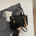 Black glossy pleated bucket bag with adjustable strap and decorative beaded pendant - Black