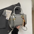 Silver bucket bag with pleated texture, circular handle and colorful beaded charm - Silver