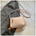 Chic beige box shoulder bag with gold hardware and rivets on a grey suit background - Pink