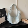 Close-up of light blue dumpling bag with glossy leather texture and pleated details - Blue