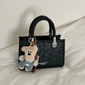 Elegante borsa a tracolla nera in ecopelle con manici intrecciati e ciondolo a orsetto - Nero