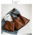 Detalle de bolso tote color café con textura de cuero y estuche pequeño a juego - Café