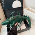 Close-up of realistic green crocodile-shaped bag showing 3D texture and gold zipper - Handheld/Shoulder Style / 47*10*14 / Green