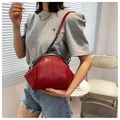 Detail of red shell crossbody bag with crossbody chain strap and quilted stitching - Red
