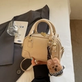 Cremefarbene Muschel-Umhängetasche aus Glattleder mit Bärenanhänger und Gold-Hardware - Mit Anhänger / Khaki