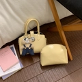 Cream yellow handbag set with brown bear charm and matching pouch on wooden floor - With Pendant / Yellow