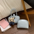 Close-up of light blue handbag set with teddy bear charm and silver lock detail - With Pendant / Blue
