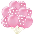 Close-up of pink and white polka dot latex balloons with golden ribbons for party decor - Pink